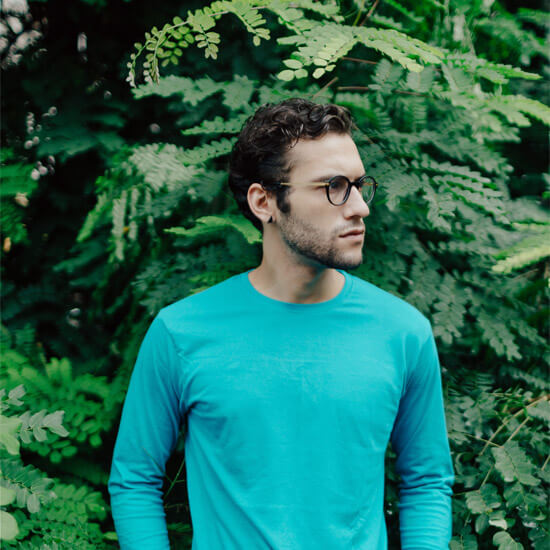 Man standing in front of green trees