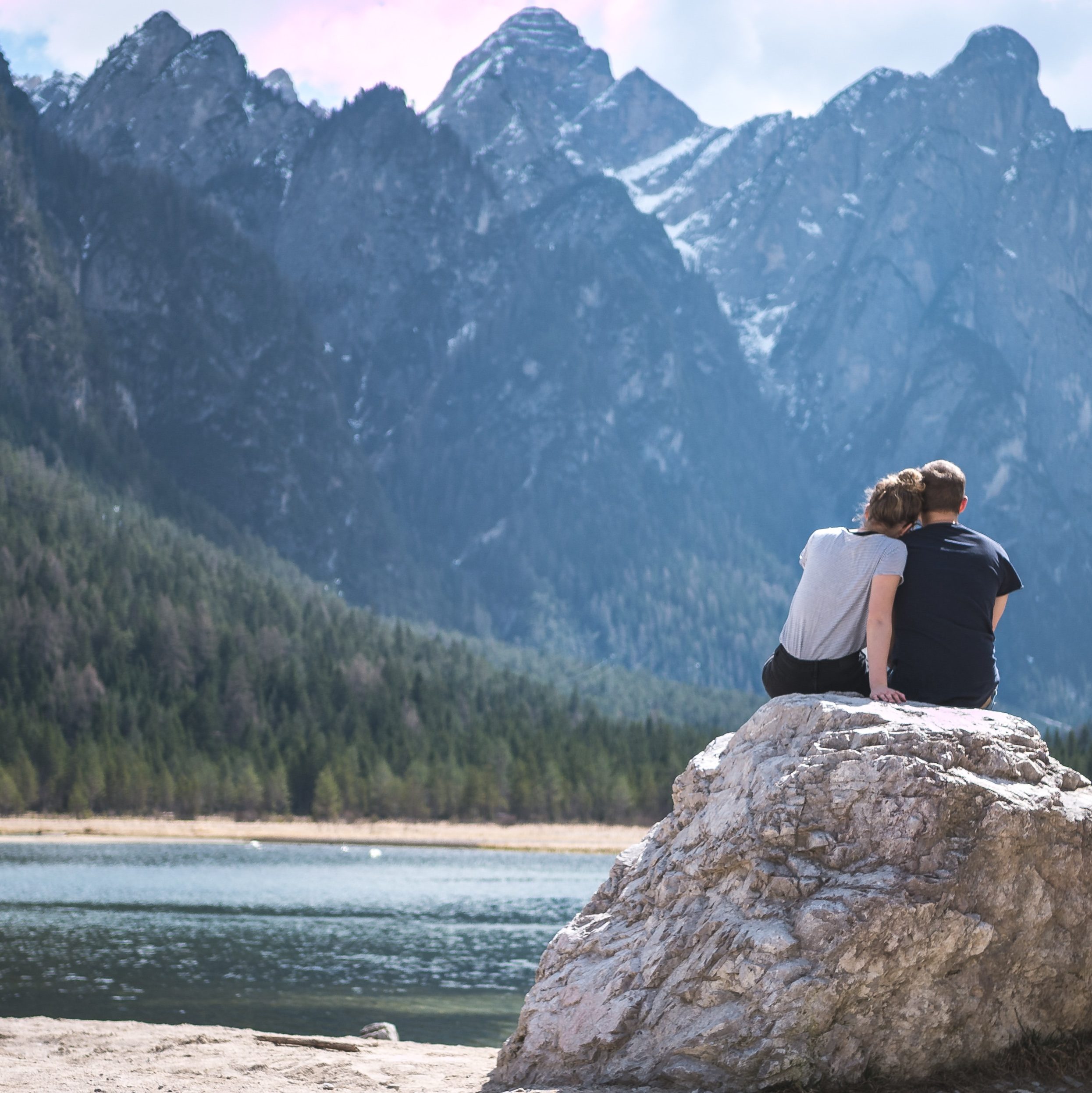 a couple sitting on a rock looking at Colorado mountains